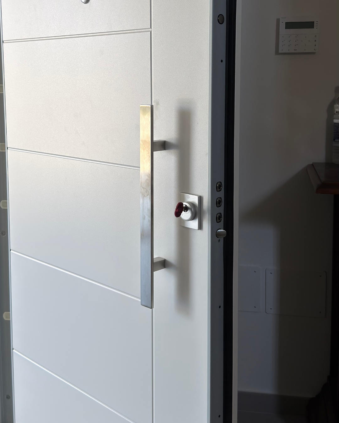 Dettaglio serratura e maniglione porta blindata bianca